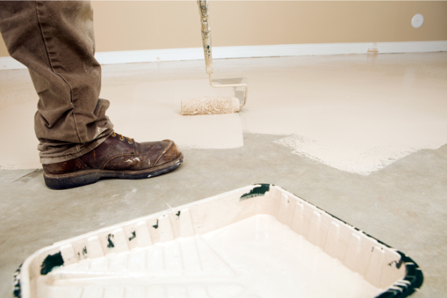 Painter Rolling Epoxy Paint on Concrete Floor